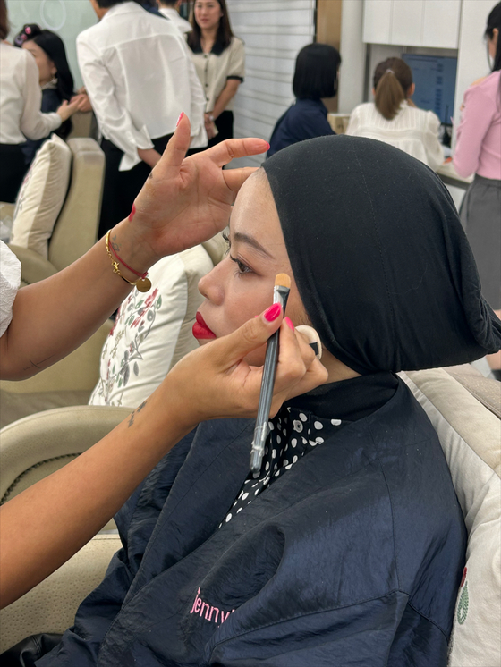 Rose Nicotine, an influencer in Malaysia, gets her makeup done by Mu Jin, the makeup artist that creates the looks for actor Son Ye-jin, on May 11. [SHIN MIN-HEE]
