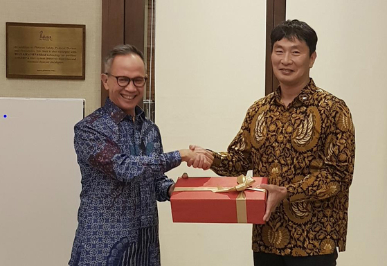 Financial Supervisory Service Gov. Lee Bok-hyun, right receives a gift from Mahendra Siregar, head of Otoritas Jasa Keuangan (OJK), Indonesia's financial regulator, in Jakarta, on May 12 after signing an MOU agreeing to work together. [YONHAP]