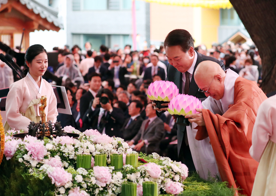 President Yoon Suk Yeol, center, bows with a lantern at a ceremony marking Buddha's Birthday at Jogye Temple in Jogno District, central Seoul on Sunday. The ceremony, led by Ven. Jinwoo, head of the Jogye Order, Korea’s largest Buddhist sect, was attended by some 10,000 people including politicians, senior government officials, leaders of other religious groups and diplomats. [JOINT PRESS CORPS]