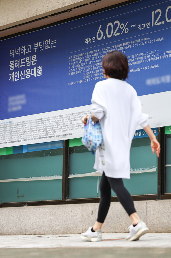 A passenger walks by a banner by a commercial bank in Seoul promoting its loan options on Monday. Korea's household debt-to-GDP ratio stood at the highest level among 34 major economies in the first quarter despite eased growth of household debts, according to the Institute of International Finance (IIF) on Monday. The ratio stood at 102.2 percent in the January-March period, followed by Hong Kong with a ratio of 95.1 percent, Thailand with 85.7 percent and Britain with 81.6 percent. [YONHAP]