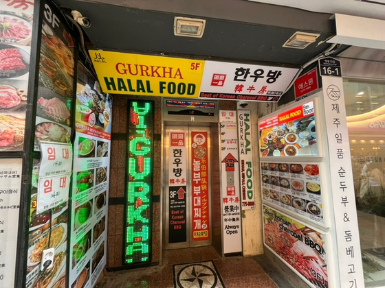 Halal food signs are displayed at the entrance of a building in Myeong-dong. [SOHN DONG-JOO]