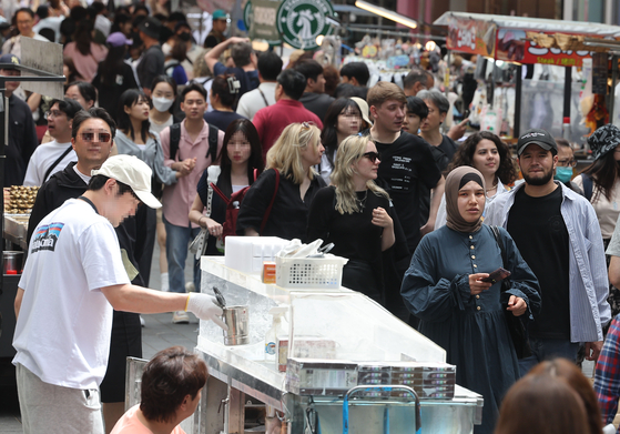 A street in Myeong-dong, central Seoul, bustles with tourists on May 21. [YONHAP]
