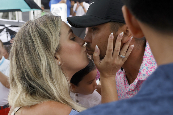 Jason Day and his wife Ellie Day celebrate after Day finished his round during the final round of the AT&T Byron Nelson at TPC Craig Ranch in McKinney, Texas, on May 14. [GETTY IMAGES]