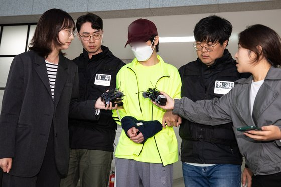 A 33-year-old man accused of revenge killing his girlfriend answers reporters' questions as he heads to the Seoul Southern District Court on Sunday for his arrest warrant review. [YONHAP] 