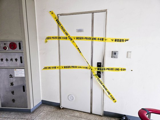 Police on Monday arrested a 30-year-old man accused of killing his father and dumping the body in a water storage tank in Jungnang District, eastern Seoul. Police lines are seen pasted on the door of his home where he lived with his parents. [JANG SEO-YUN]