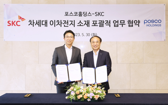 SKC CEO Park Won-cheol, left, poses with Yoo Byung-ok, vice president of Posco Holdings after signing an agreement on the battery materials partnership in central Seoul on May 30. [SKC] 