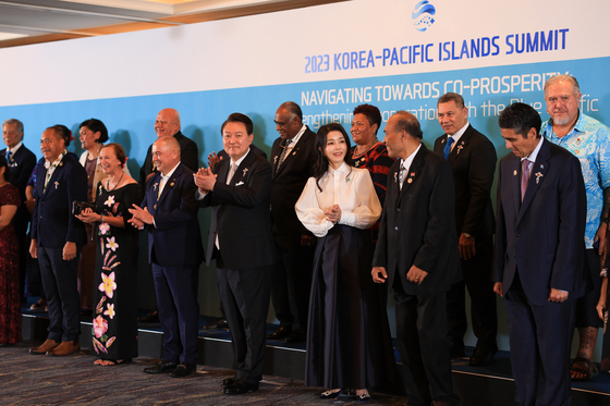Korean President Yoon Suk Yeol, center, and first lady Kim Keon-hee take a commemorative photo at an official dinner for leaders of the Pacific Islands at a hotel in central Seoul Monday after holding the inaugural Korea-Pacific Islands Summit. [PRESIDENTIAL OFFICE]