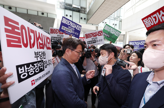 Lee Ho-chan, MBC reporter and head of MBC’s labor union, left, faces investigators from Seoul Metropolitan Police Agency’s anti-corruption and public crime investigation division as they try to enter the newsroom to conduct a seizure operation against MBC reporter Lim Hyun-joo on Tuesday. Lim is accused of leaking personal information about Justice Minister Han Dong-hoon, including his residential number and home address as well as his real estate transaction. The police withdrew an hour later. In November, a group of YouTubers banged on the door and rattled the knob of Justice Minister's Han apartment after his info was leaked. [YONHAP]