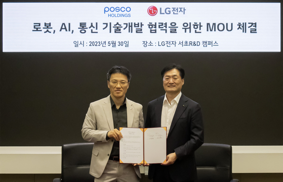 Kim Byoung-hoon, executive vice president at LG Electronics, poses with Kim Ji-yong, chief technology officer at Posco, after signing an agreement Tuesday in southern Seoul. [POSCO HOLDINGS]