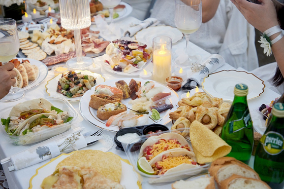 Guests bring their own plates, cups, cutlery and food to Dîner en Blanc Seoul at Banpo Han River Park, southern Seoul, on Saturday [COMMUNIQUE]