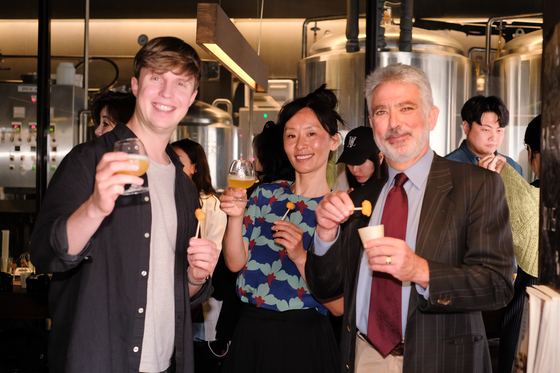From left, Julian Quintart, a Belgian TV personality in Korea; Ae Jin Huys, the owner of Korean food business in Belgium “Mokja!”; and Francois Bontemps, Belgian ambassador to Korea, pose for photos during the Belgium fries press event on Friday in Mapo District, western Seoul. [FLANDERS' AGRICULTURAL MARKETING BOARD]  