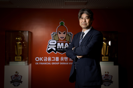 Masaji Ogino poses for a photo in front of the Ansan OK Financial Group Okman logo on Monday. [YONHAP]