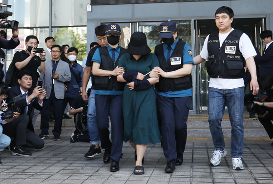 Jung Yoo-jung, a murder suspect in Busan, leaves a police station to head to the prosecutors on Friday morning. [NEWS1]