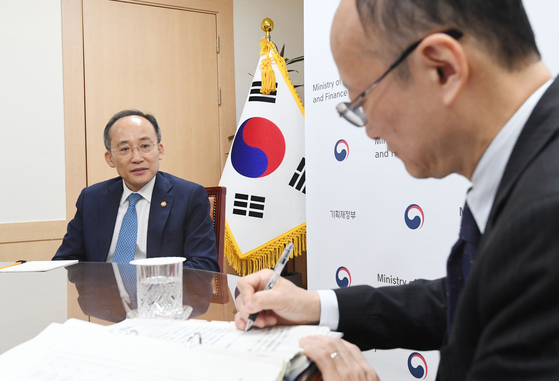 Korean Finance Minister Choo Kyung-ho, left, speaks with Japanese Vice Finance Minister Masato Kanda in Seoul on Friday. [NEWS1]