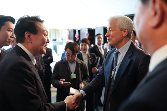 JPMorgan Chase CEO Jamie Dimon, right, shakes hands with President Yoon Suk Yeol during the Davos forum on Jan. 19. [PRESIDENTIAL OFFICE]