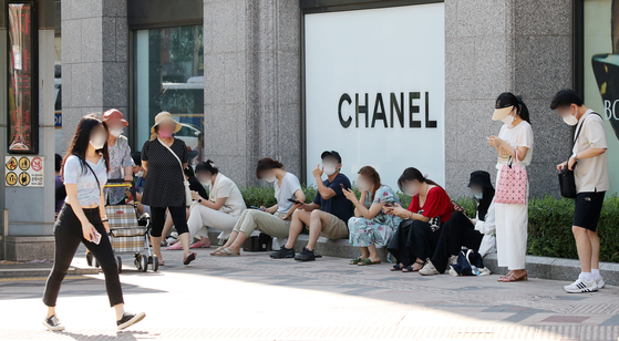 People line up in front of a Chanel store in Seoul before the store opens on July 21, 2021. [NEWS1] 