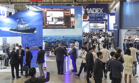Visitors look around exhibition booths at a convention center in Busan for the three-day International Maritime Defense Industry Exhibition (Madex) that runs through Friday. [YONHAP]