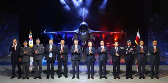 Polish Defense Minister Mariusz Blaszczak and Korean Defense Minister Lee Jong-sup stand in the center of a photo lineup at a Wednesday ceremony in Sacheon, South Gyeongsang, marking the rollout of the first FA-50 light attack aircraft designated for export to Poland. [KOREA AEROSPACE INDUSTRIES]