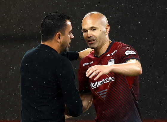 Vissel Kobe's Andres Iniesta, right, hugs Xavi Hernandez during a friendly with FC Barcelona at National Stadium in Tokyo, Japan on Tuesday. [REUTERS/YONHAP]