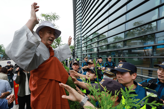 A Buddhist monk of the Jogye order protests the Japanese government’s plan to release treated radioactive water from the Fukushima Daiichi Nuclear Power Plant this summer in front of the Japanese embassy in Jongno District, central Seoul, on Wednesday. The Daiichi Nuclear Power Plant earlier this week filled the tunnel built to release the treated water into the sea, the final stage before the actual release. [YONHAP]