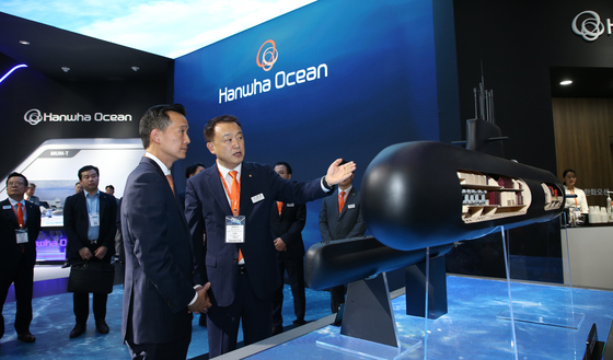 Hanwha Vice Chairman Kim Dong-kwan looks at a model of the Jang Bogo-III Batch-II at the Hanwha Ocean exhibition booth at Madex in Busan on Wednesday. [HANWHA OCEAN]