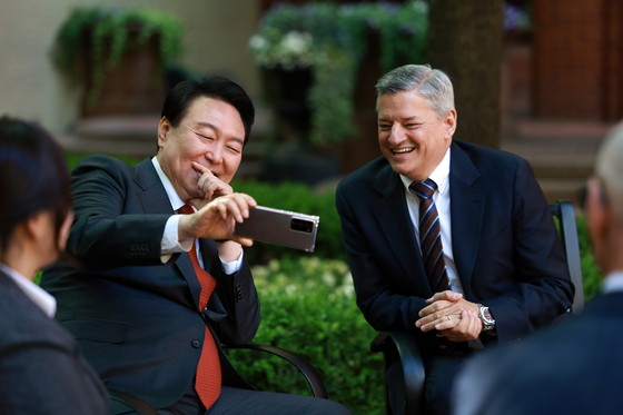 President Yoon Suk Yeol, left, shows Netflix co-CEO Ted Sarandos a video of his ceremonial first pitch at a professional baseball game at a meeting at Blair House in Washington on April 25. [NEWS1]