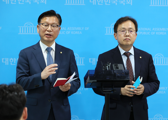 People Power Party Rep. Lee Yang-soo, left, and Democratic Party Rep. Song Ki-hun explains the parties’ agreement at the National Assembly, Thursday. [YONHAP]