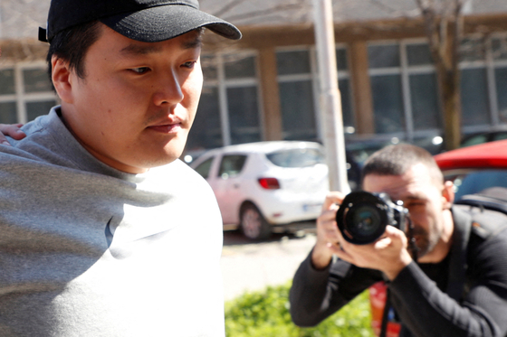 Do Kwon, the cryptocurrency entrepreneur who created the failed Terra (UST) stablecoin, is taken to court in handcuffs, to face charges of forging official documents, in Podgorica, Montenegro, March 24, 2023. [REUTERS/YONHAP]
