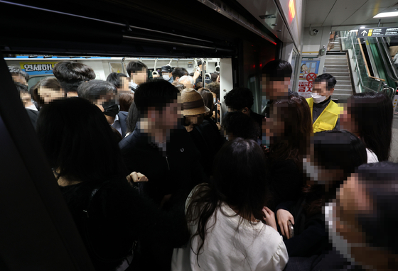 Commuters try to get on a crowded train car at Gochon Station on Gimpo Gold Line on May 9. [YONHAP] 