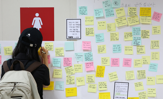 A passerby leaves a message near a women's bathroom in Sindang Station on Sept. 16, 2022 to commemorate the death of the victim killed by stalker-murderer Jeon Joo-hwan. {YONHAP] 