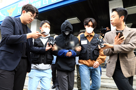 A Philippines national sent to the prosecution on charges of smuggling drugs into Korea is escorted out of Yongsan Police Precinct on May 12. [NEWS1]