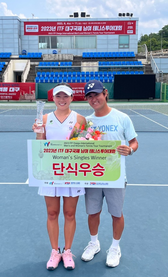 Park So-hyun, left, poses for a photo with her coach Yasuo Nishioka after winning the singles title at the 2023 ITF Daegu in Daegu on Sunday, a day after she won the doubles event at the same competition with Cody Wong of Hong Kong.  [YONEX]