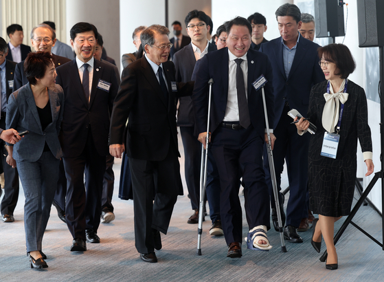 Chey Tae-won, second from right in the front row, chairman of the Korea Chamber of Commerce and Industry, smiles as he appears, wearing a cast after a leg injury, with Ken Kobayashi, third from right, the chairperson of the Japan Chamber of Commerce and Industry for their meeting at a hotel in Busan on Friday. [YONHAP] 