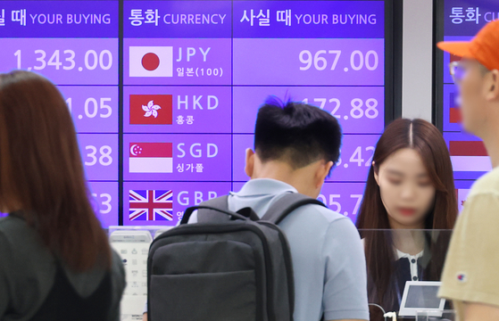 People visit a currency exchange booth at Incheon International Airport on Monday. The number of travelers to Japan is increasing with the yen falling to record-low levels, trading at around 920 won per 100 yen. [YONHAP]