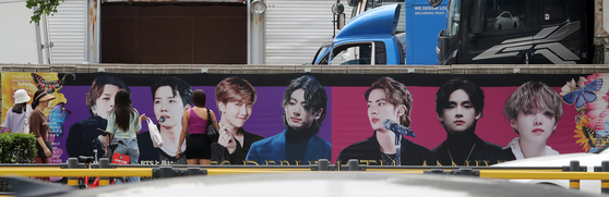 A placard of BTS members is hung up near HYBE headquarters in central Seoul on Monday as a part of the ″2023 BTS Festa″ event to celebrate the band's 10th anniversary of debut that falls on Tuesday. [NEWS1]