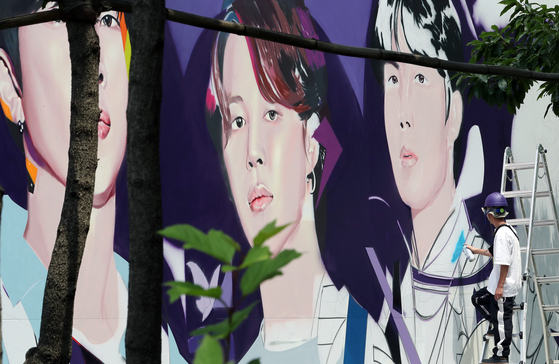 BTS members' faces are being painted on HYBE headquarters' walls on Monday in central Seoul, in celebration of the boy band's 10th anniversary of debut that falls on Tuesday. [NEWS1]