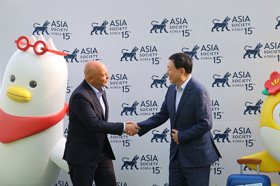 Lotte Group Chairman Shin Dong-bin, right, shakes hands with Ambassador Khaled Abdel Rahman, the Egyptian ambassador to Korea, during the commemorative dinner marking the 15th anniversary of the establishment of Asiana Society Korea at the Signiel Hotel in Busan on Monday. [LOTTE GROUP]