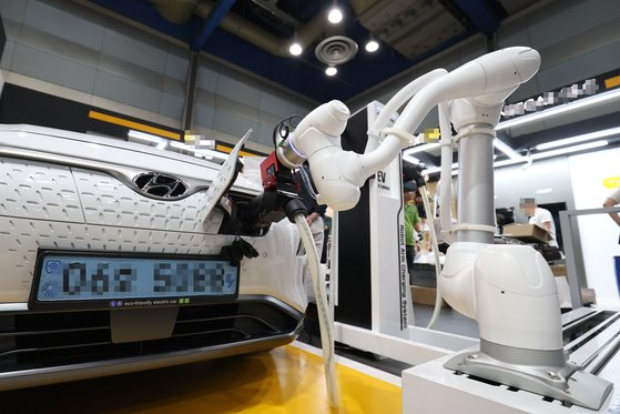A robot plugs a charger into an electric vehicle. [SEOUL METROPOLITAN GOVERNMENT] 