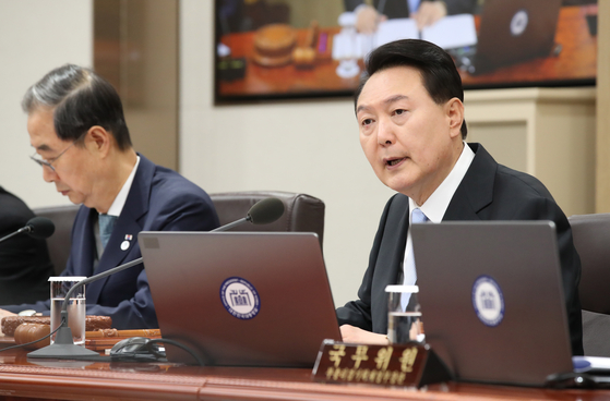 President Yoon Suk Yeol, right, presides over a Cabinet meeting on Tuesday at the presidential office in Yongsan District, central Seoul. [YONHAP]