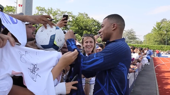 Kylian Mbappe signs autographs at training. [ONE FOOTBALL]