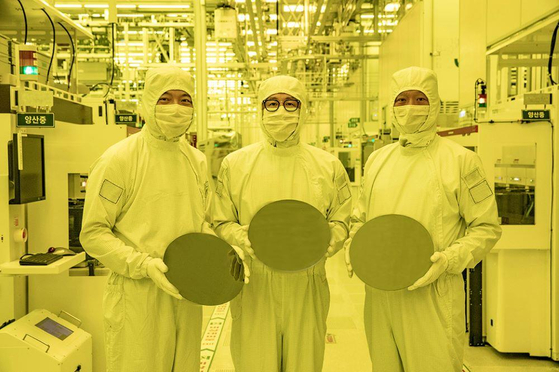 Samsung Electronics executives hold 3-nanometer wafers at its factory in Hwaseong Campus in Gyeonggi in July 2022. [YONHAP]