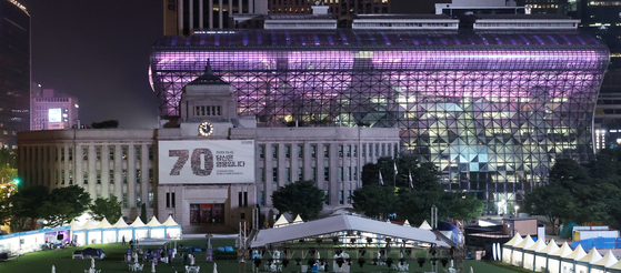 The City Hall building in central Seoul is lit in purple on Monday, as part of the ″2023 BTS Festa″ held in celebration of K-pop boy band BTS's 10th anniversary of its debut. [YONHAP]