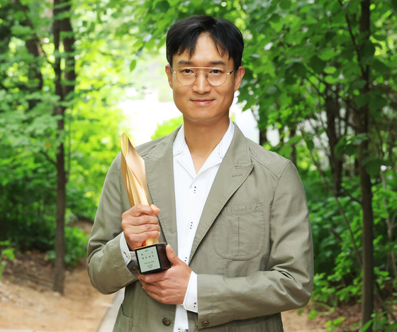 Actor Jo Woo-jin holds his trophy for Best Supporting Actor award given at the 59th Baeksang Arts Awards after an interview with the Korea JoongAng Daily held at JTBC headquarters in western Seoul. [BAEKSANG ARTS AWARDS ORGANIZING COMMITTEE]