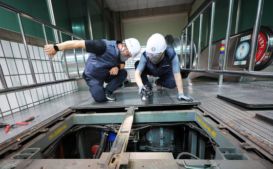 A group of investigators including the Korea Railway Police and the National Forensic Service inspects the escalator at Sunae subway station in Bundang, Gyeonggi, on Tuesday. Some 14 people were injured when the escalator went in reverse on June 8. [YONHAP]