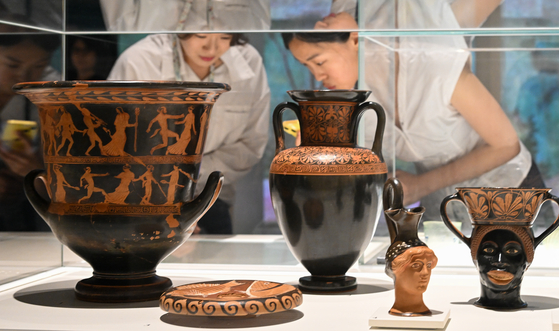 Visitors view Greek pottery vessels at the National Museum of Korea's new exhibition “Separate But Inseparable: Mythology and Culture of Ancient Greece and Rome” in Yongsan District, central Seoul. [NEWS1]