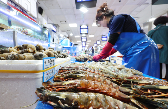 A vendor at Noryangjin Fisheries Wholesale Market in Dongjak District, southern Seoul lays out seafood at her stall on Thursday. The National Federation of Fisheries Cooperatives launched an event in collaboration with seafood suppliers, vendors and consumer groups at the market the same day, urging people to continue buying seafood despite contamination fears. [YONHAP]