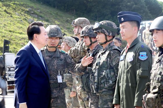 President Yoon Suk Yeol, left, greets troops, observing the largest-ever combined live-fire drill with South Korean and U.S. forces at the Seungjin Fire Training Field in Pocheon, Gyeonggi, near the inter-Korean border on Thursday. [JOINT PRESS CORPS]