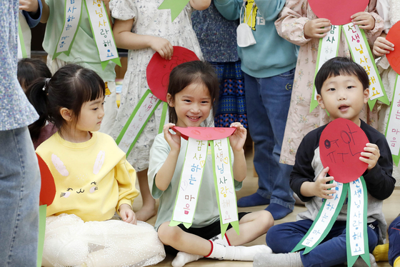 Children thank their teachers with paper carnations for the Teacher's Day on May 15 at a daycare center in Gwangju. [YONHAP]
