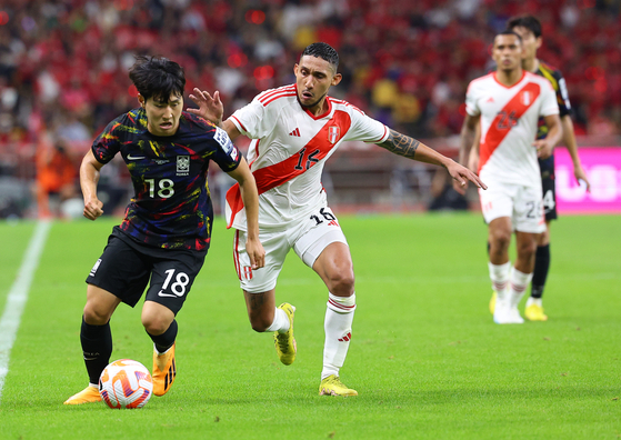 Korea's Lee Kang-in, left, dribbles the ball during a friendly against Peru at Busan Asiad Stadium in Busan on Friday. [YONHAP] 