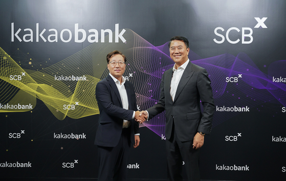 KakaoBank CEO Yoon Ho-young, left, and SCBX CEO Arthid Nanthawithaya sign a partnership deal on Thursday at SCBX headquarters in Bangkok, Thailand.  